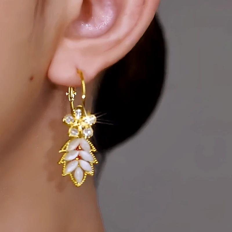 Model showcasing the dangle and style of the 14K Gold-Plated Elegant Zircon Flower Leaf Tassel Earrings