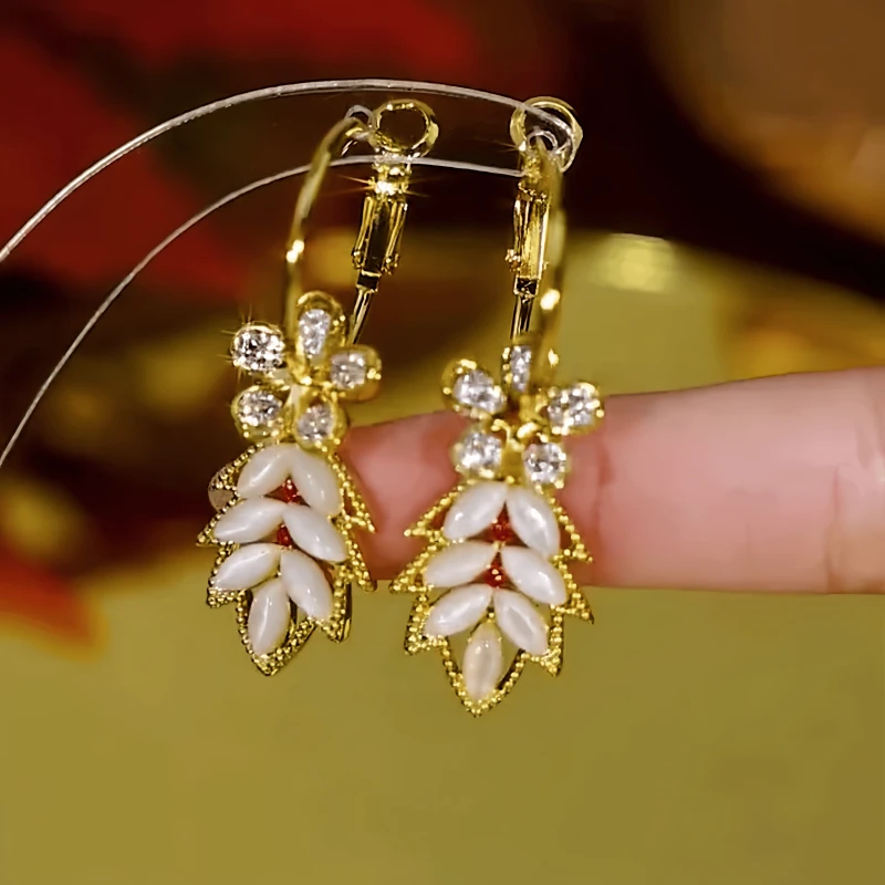 Close-up detail of the sparkling zircons and plating on the gold tassel earrings