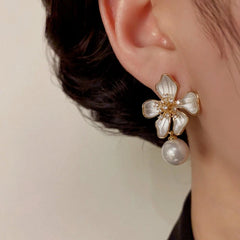 Model showcasing the dangle and style of the 14K Gold-Plated Elegant Zircon Flower Pearl Earrings