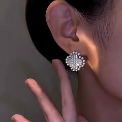 Close-up detail of the sparkling zircons and plating on the silver flower earrings