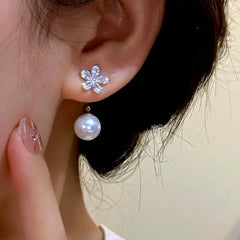 Model showcasing the dangle and style of the 14K Gold-Plated Elegant Zircon Flower Pearl Jacket Earrings