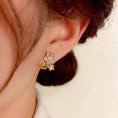 Model showcasing the dangle and style of the 14K Gold-Plated Elegant Zircon Flower Pearl Stud Earrings