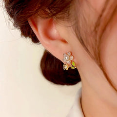 Close-up detail of the sparkling zircons and plating on the gold flower earrings