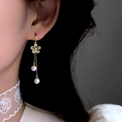 Close-up detail of the sparkling zircons and plating on the gold tassel earrings