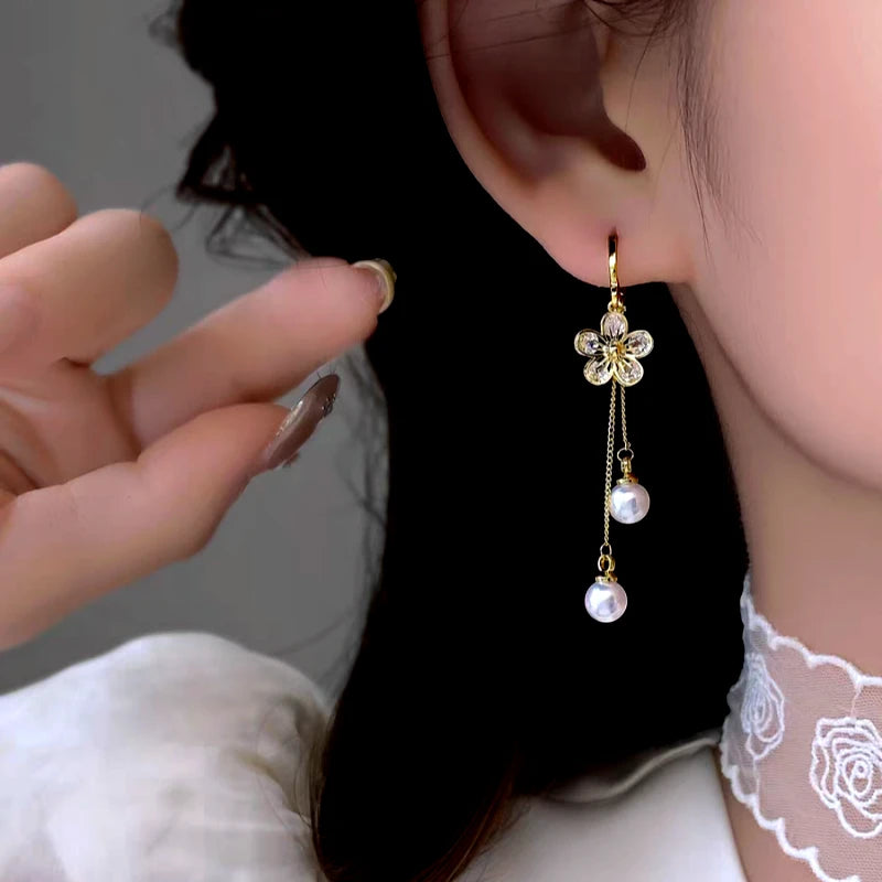 Model showcasing the dangle and style of the 14K Gold-Plated Elegant Zircon Flower Pearl Tassel Earrings