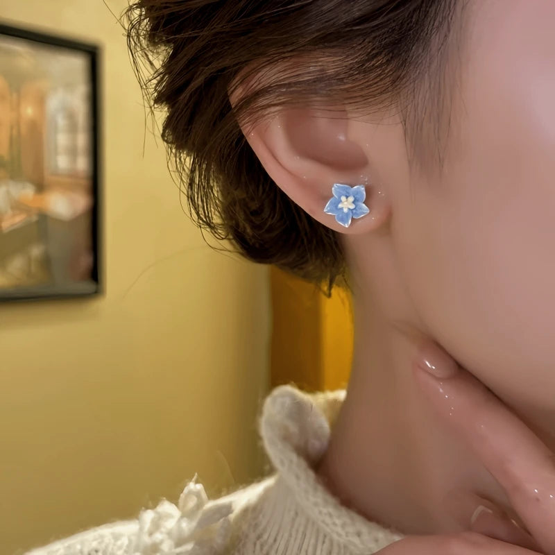 Model showcasing the dangle and style of the 14K Gold-Plated Elegant Zircon Flower Stud Earrings