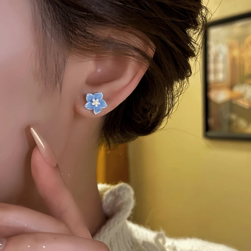 Close-up detail of the sparkling zircons and plating on the blue flower earrings