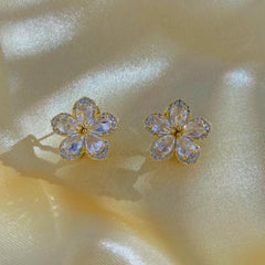 Close-up detail of the sparkling zircons and plating on the gold flower earrings