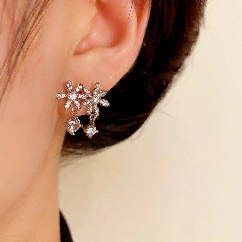 Model showcasing the dangle and style of the 14K Gold-Plated Elegant Zircon Flower Tassel Earrings