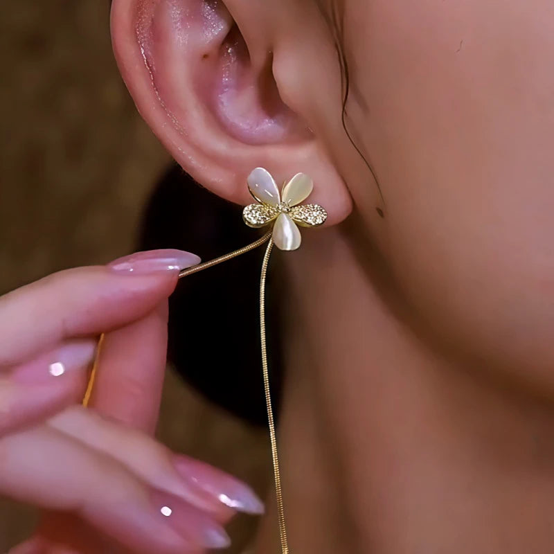 Model showcasing the dangle and style of the 14K Gold-Plated Elegant Zircon Flower Tassel Earrings
