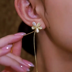 Model showcasing the dangle and style of the 14K Gold-Plated Elegant Zircon Flower Tassel Earrings