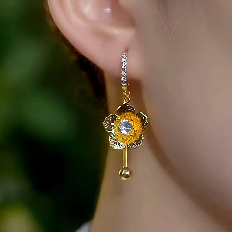 Model showcasing the dangle and style of the 14K Gold-Plated Elegant Zircon Flower Tassel Earrings