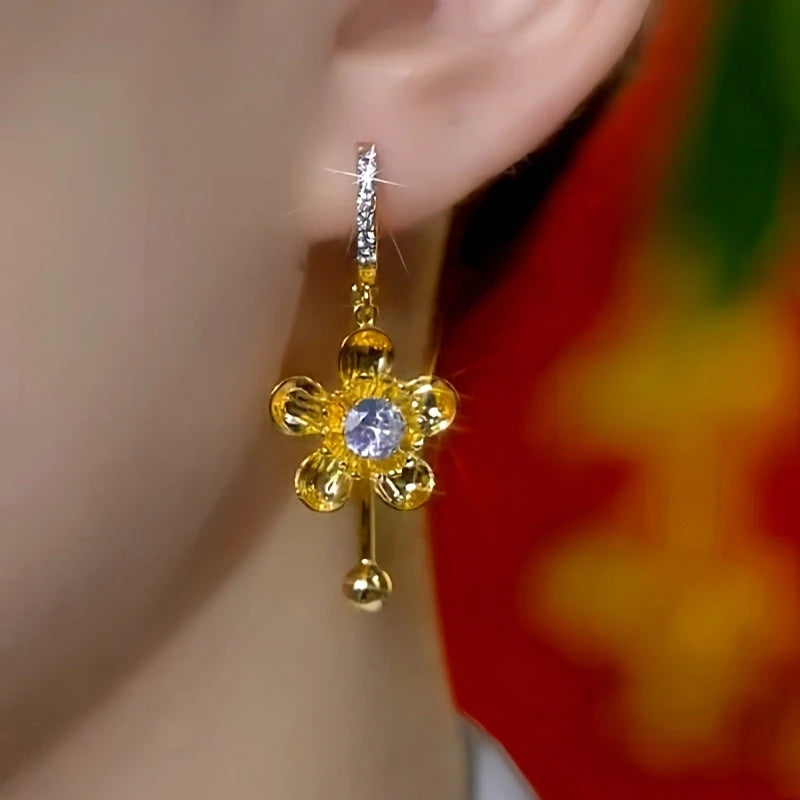 Model showcasing the dangle and style of the 14K Gold-Plated Elegant Zircon Flower Tassel Earrings