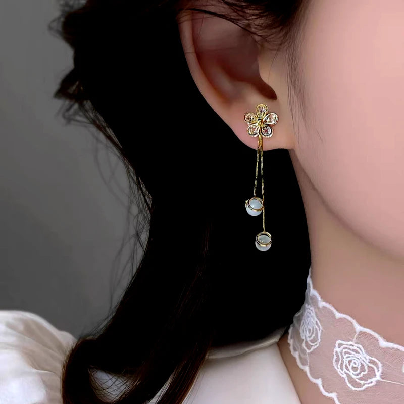 Close-up detail of the sparkling zircons and plating on the gold tassel earrings