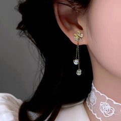 Close-up detail of the sparkling zircons and plating on the gold tassel earrings