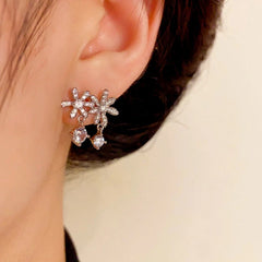 Model showcasing the dangle and style of the 14K Gold-Plated Elegant Zircon Flower Tassel Earrings