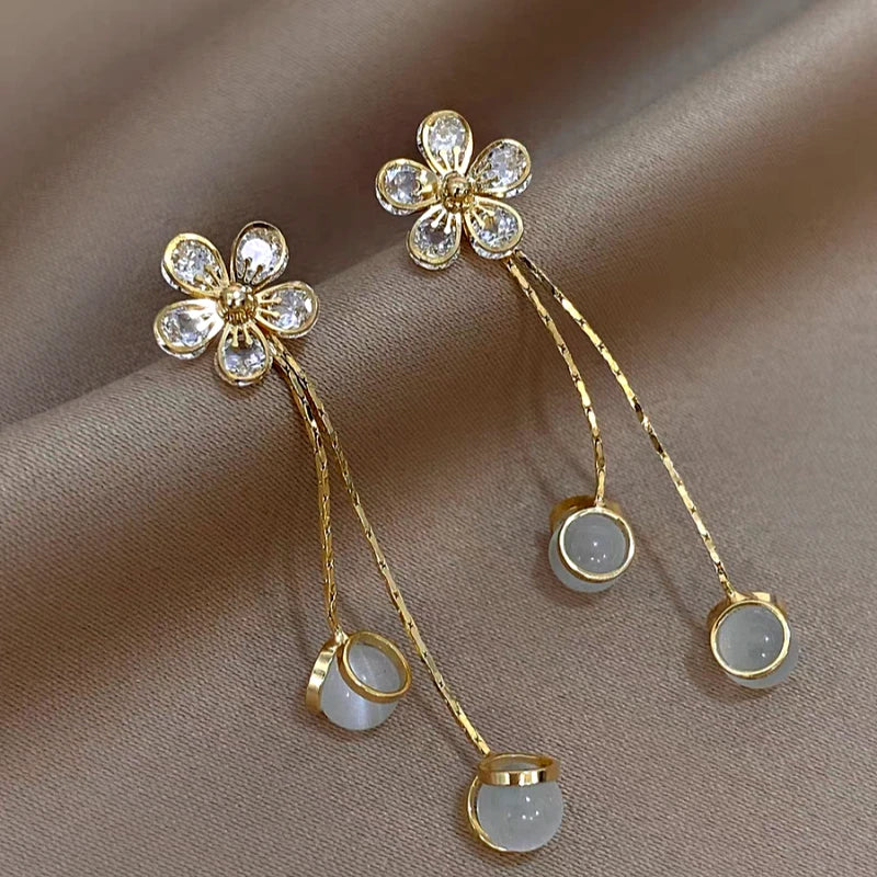 Model showcasing the dangle and style of the 14K Gold-Plated Elegant Zircon Flower Tassel Earrings