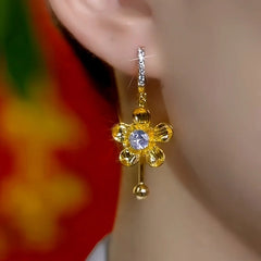 Close-up detail of the sparkling zircons and plating on the gold tassel earrings