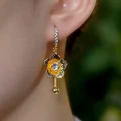 Close-up detail of the sparkling zircons and plating on the gold tassel earrings