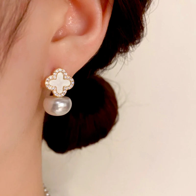 Model showcasing the dangle and style of the 14K Gold-Plated Elegant Zircon Four-Leaf Flower Pearl Earrings