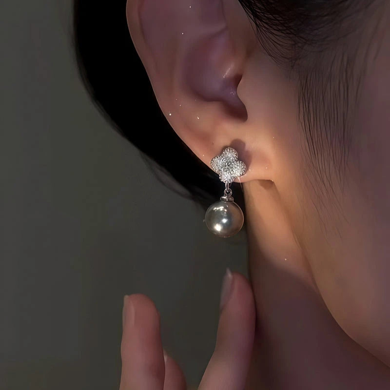 Model showcasing the dangle and style of the 14K Gold-Plated Elegant Zircon Four-Leaf Pearl Earrings