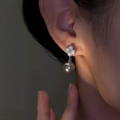 Model showcasing the dangle and style of the 14K Gold-Plated Elegant Zircon Four-Leaf Pearl Earrings