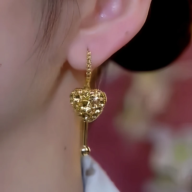 Model showcasing the dangle and style of the 14K Gold-Plated Elegant Zircon Full Diamond Heart Earrings