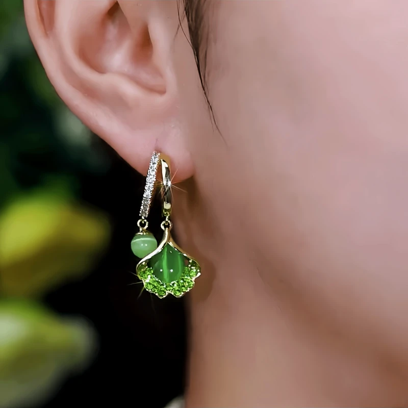 Model showcasing the dangle and style of the 14K Gold-Plated Elegant Zircon Ginkgo Earrings