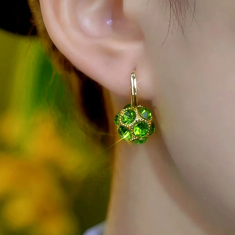 Model showcasing the dangle and style of the 14K Gold-Plated Elegant Zircon Green Balls Earrings