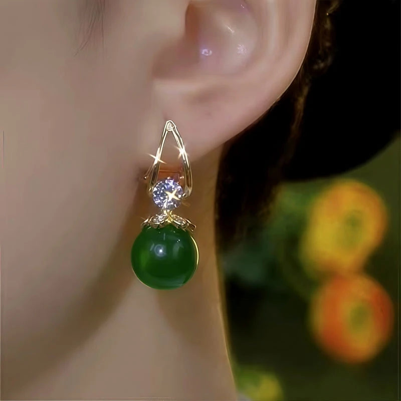 Model showcasing the dangle and style of the 14K Gold-Plated Elegant Zircon Green Bead Earrings