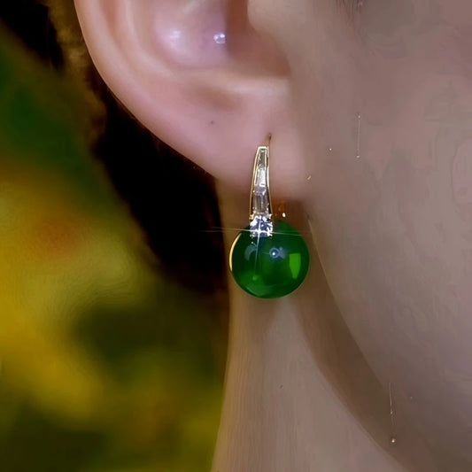 Model showcasing the dangle and style of the 14K Gold-Plated Elegant Zircon Green Bead Earrings