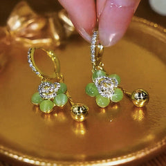 Close-up detail of the sparkling zircons and plating on the green flower earrings