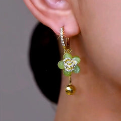 Model showcasing the dangle and style of the 14K Gold-Plated Elegant Zircon Green Cat's Eye Flower Earrings