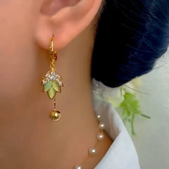 Close-up detail of the sparkling zircons and plating on the green tassel earrings
