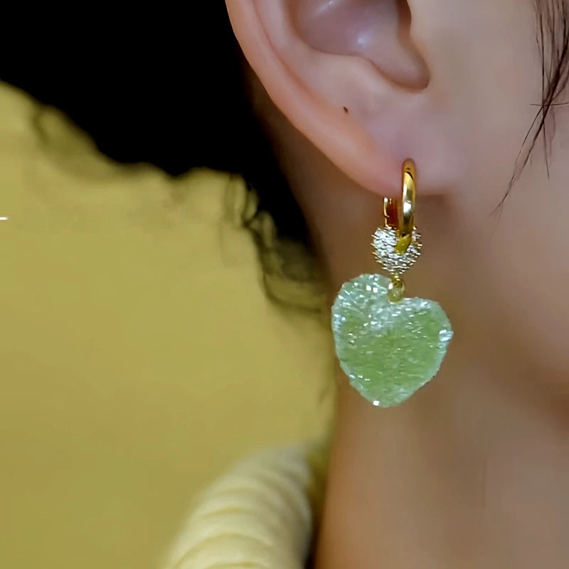 Model showcasing the dangle and style of the 14K Gold-Plated Elegant Zircon Green Crystal Heart Earrings