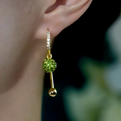 Close-up detail of the sparkling zircons and plating on the green tassel earrings