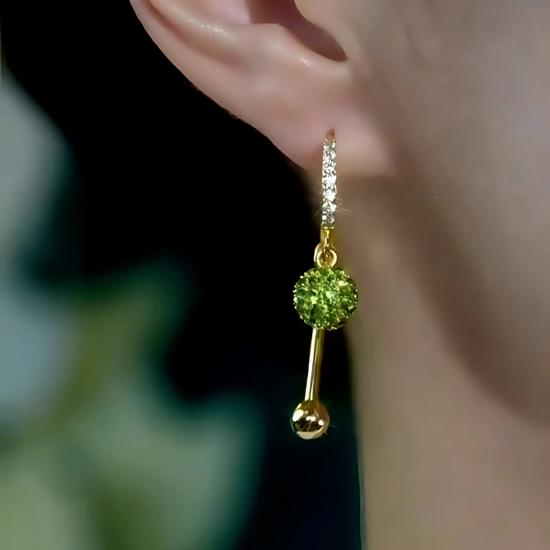 Model showcasing the dangle and style of the 14K Gold-Plated Elegant Zircon Green Diamod Ball Tassel Earrings
