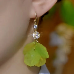 Close-up detail of the sparkling zircons and plating on the green tassel earrings