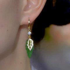 Close-up detail of the sparkling zircons and plating on the green leaf earrings