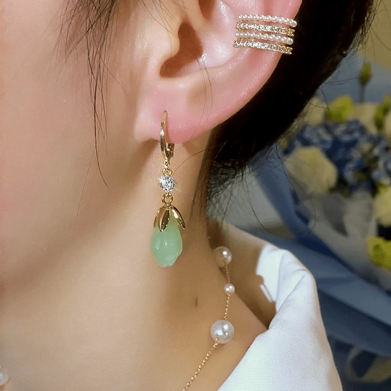Model showcasing the dangle and style of the 14K Gold-Plated Elegant Zircon Green Magnolia Earrings