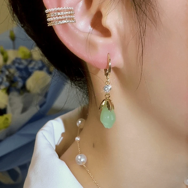 Close-up detail of the sparkling zircons and plating on the green flower earrings