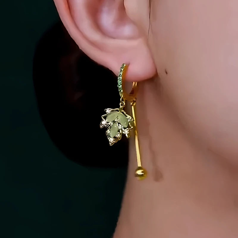 Model showcasing the dangle and style of the 14K Gold-Plated Elegant Zircon Green Maple Leaf Earrings