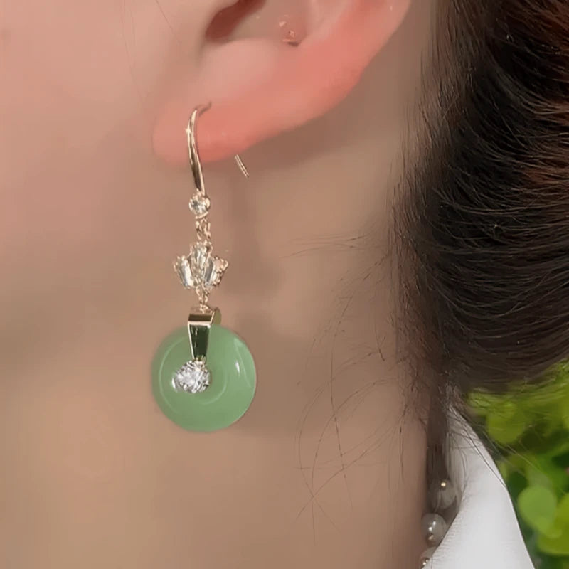 Model showcasing the dangle and style of the 14K Gold-Plated Elegant Zircon Green Round Peace Ear Hooks