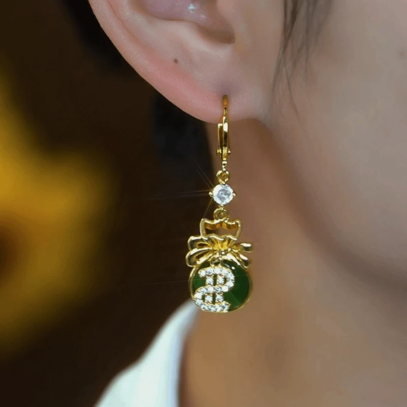 Model showcasing the dangle and style of the 14K Gold-Plated Elegant Zircon Green $ Lucky Bag Earrings