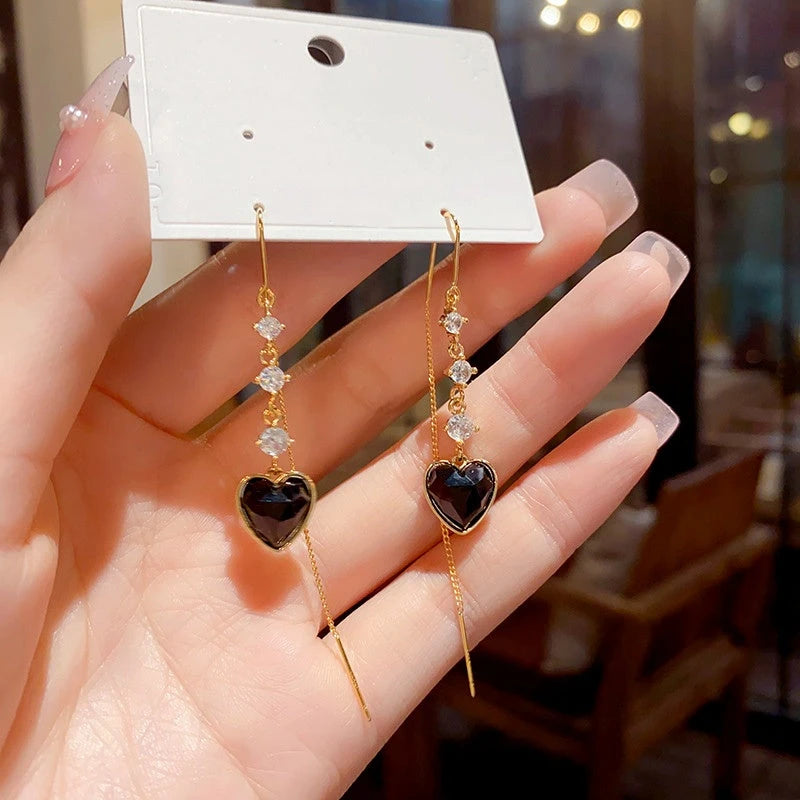 Model showcasing the dangle and style of the 14K Gold-Plated Elegant Zircon Heart-Design Tassel Threader Earrings