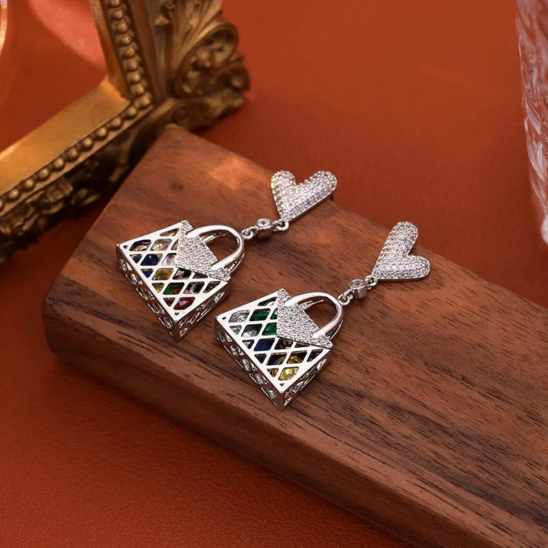 Model showcasing the dangle and style of the 14K Gold-Plated Elegant Zircon Heart Bag Tassel Earrings