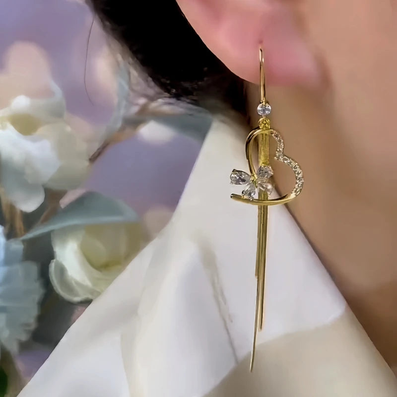 Model showcasing the dangle and style of the 14K Gold-Plated Elegant Zircon Heart Butterfly Tassel Ear Hooks