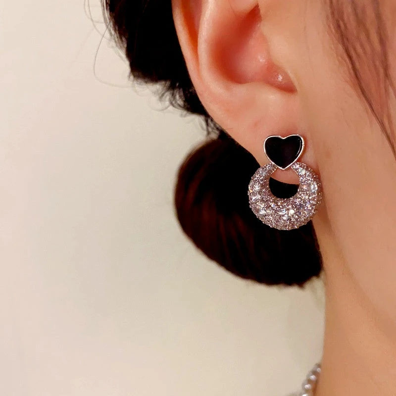 Model showcasing the dangle and style of the 14K Gold-Plated Elegant Zircon Heart Earrings