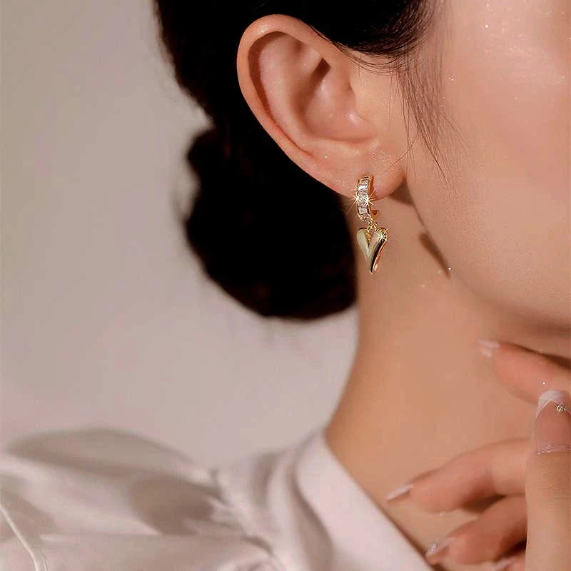 Close-up detail of the sparkling zircons and plating on the gold heart earrings