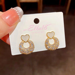 Close-up detail of the sparkling zircons and plating on the gold heart earrings